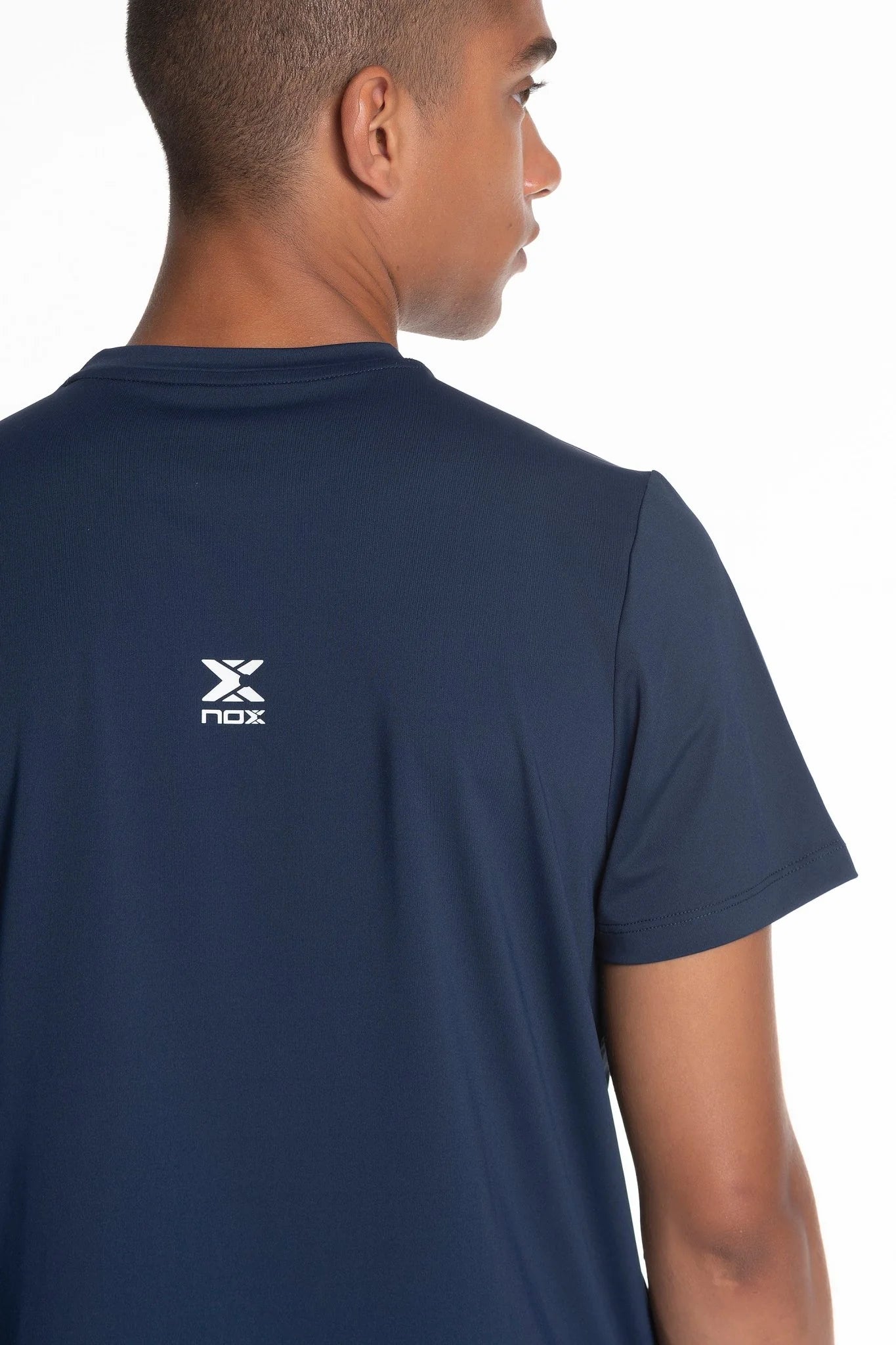 Model wearing navy blue shirt with a logo on the back