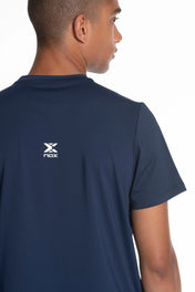 Model wearing navy blue shirt with a logo on the back